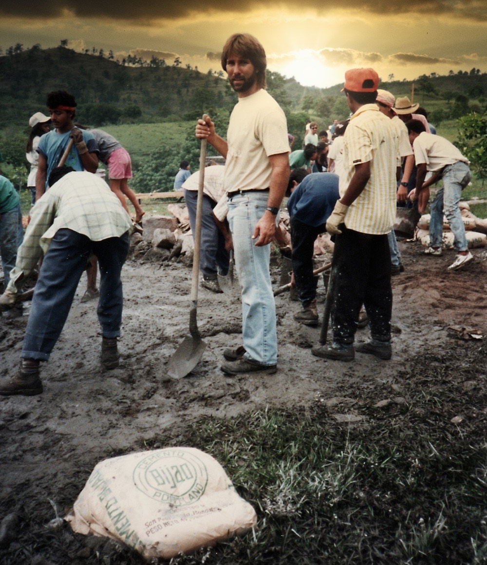  Helping lay a new building foundation with wet concrete rake 